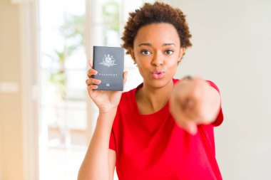 Avustralya pasaportu taşıyan genç Afro-Amerikan kadın kameraya ve size parmakla işaret eden, el işareti, önden olumlu ve kendinden emin jest