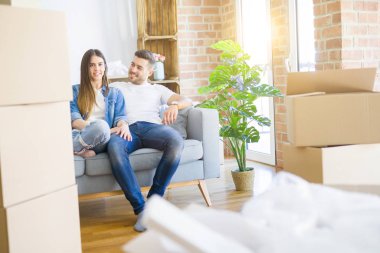 Aşık genç çift yeni evde kanepede oturan rahatlatıcı, s