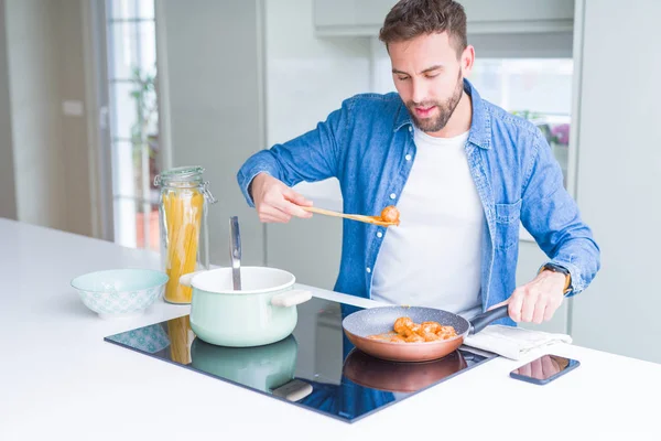 Hombre guapo cocinando pasta en casa — Foto de Stock