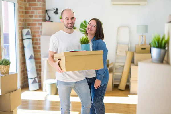 Casal jovem se mudando para uma nova casa, sorrindo feliz segurando cardboa — Fotografia de Stock