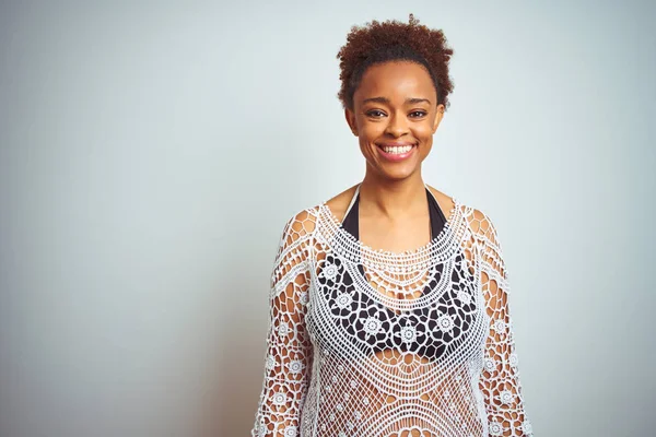 Young african american woman with afro hair wearing a bikini over white isolated background with a happy and cool smile on face. Lucky person.