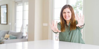 Evde korku ve korkudan korkan genç kadın elleriyle jesti durdurarak, şok içinde bağırıyor. Panik kavramı.