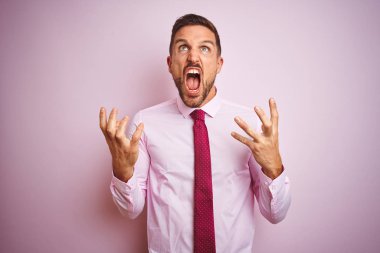 Pembe izole arka plan deli ve deli bağırarak ve agresif ifade ve kollar kaldırdı ile bağırarak üzerinde kravat ve zarif gömlek giyen iş adamı. Hayal kırıklığı kavramı.