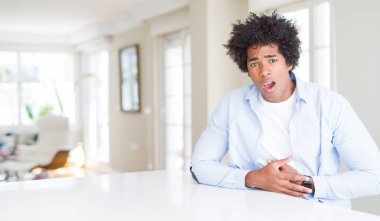 Afrikalı-Amerikalı adam evde el mide ile çünkü mide bulantısı, ağrılı hastalık hasta hissediyor. Ağrısı kavramı.