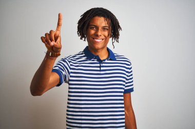 Çizgili mavi polo giyen dreadlocks giyen Afro adam izole beyaz arka plan üzerinde duran gösteren ve emin ve mutlu gülümserken parmak sayısı bir işaret.