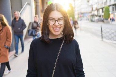 Güzel genç esmer kadın gülümsüyor heyecanlı yürürken 