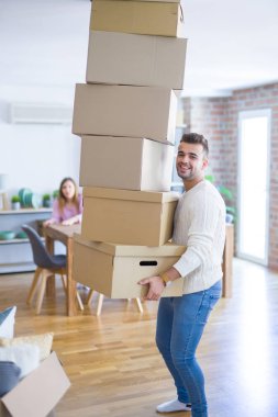 Yeni bir eve taşınan genç çift, karton kutular tutan adam 