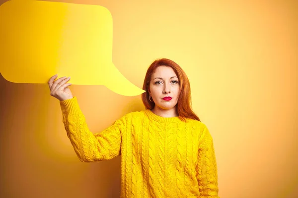 Joven Hermosa Pelirroja Sosteniendo Burbuja Del Habla Sobre Fondo Amarillo —  Fotos de Stock