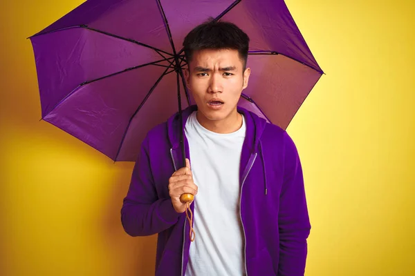 Asiático Chinês Homem Vestindo Roxo Guarda Chuva Sobre Isolado Amarelo — Fotografia de Stock