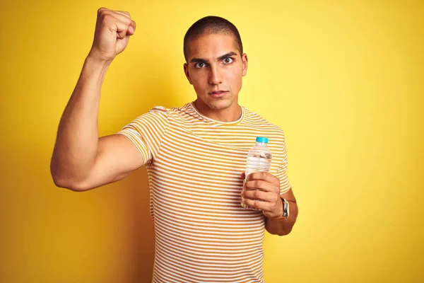 Joven Hombre Guapo Sosteniendo Botella Agua Plástico Sobre Fondo Aislado —  Fotos de Stock