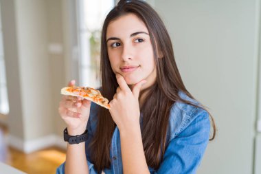 Güzel genç kadın lezzetli pizza ciddi yüz soru hakkında düşünme bir dilim yemek, çok karışık bir fikir