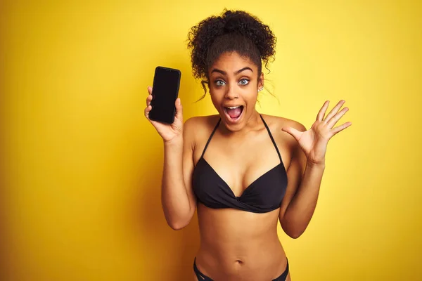 Donna Afroamericana Che Indossa Bikini Mostrando Smartphone Sfondo Giallo Isolato — Foto Stock