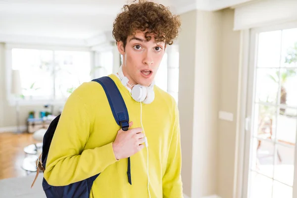 Młody Student Mężczyzna Noszenie Słuchawek Plecak Przestraszony Szoku Niespodzianką Twarz — Zdjęcie stockowe