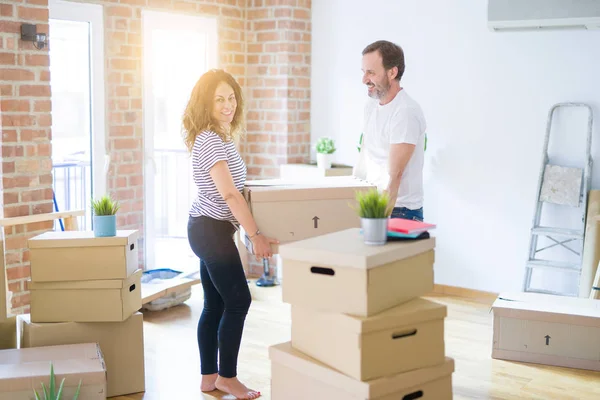 Seniorenpaar mittleren Alters zieht in ein neues Haus und hält Pappkarton — Stockfoto