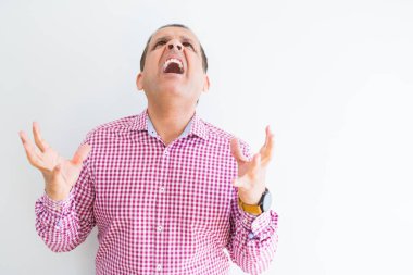 Orta yaş adam beyaz duvar üzerinde iş gömleği giyen deli ve deli bağırarak ve agresif ifade ve kollar kaldırdı ile bağırıyor. Hayal kırıklığı kavramı.