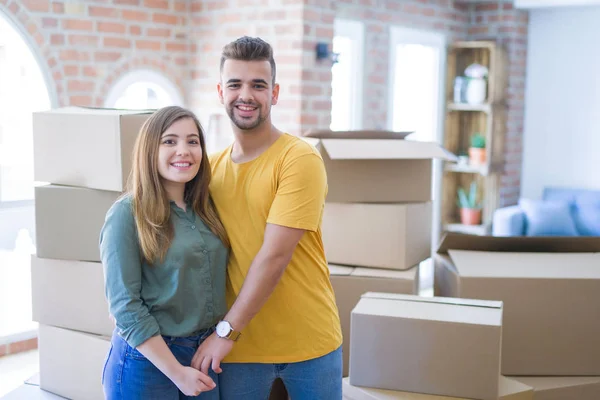 Junges schönes verliebtes Paar um Pappkartons zieht um — Stockfoto