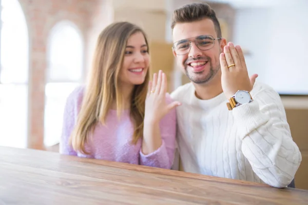 Mladý veselý pár se spokojeným úsměvem ukazující svatební prsten, celebr — Stock fotografie