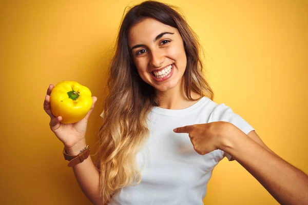 Giovane Bella Donna Possesso Pepe Sfondo Giallo Isolato Con Faccia — Foto Stock