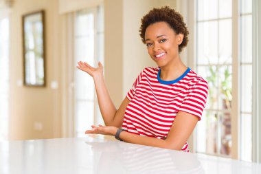 Genç güzel afro-amerikan kadın evde açık el ile doğal gülümseyen girmek için davet