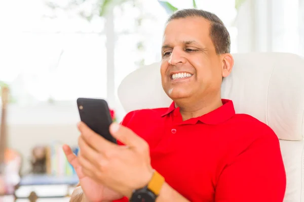 Hombre de mediana edad sonriendo alegre blanco usando teléfono inteligente sentado o —  Fotos de Stock