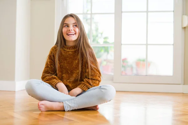 美丽的少女孩子坐在地板上 在家里看着远方 面带微笑 表情自然 笑自信 — 图库照片