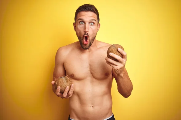 Young Handsome Shirtless Man Holding Exotic Tropical Coconut Isolated Yellow — Stock Photo, Image