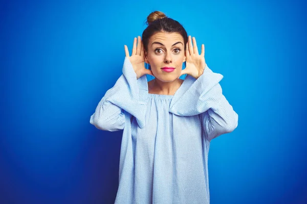 Jonge Mooie Vrouw Dragen Bun Kapsel Blauwe Geïsoleerde Achtergrond Proberen — Stockfoto