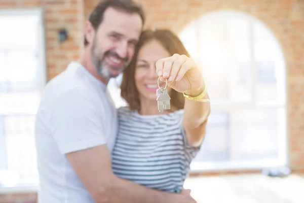 Medelålders Senior romantiskt par som håller och visar hus nycklar — Stockfoto