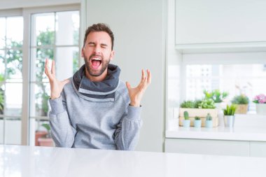 Yakışıklı adam evde deli ve deli silah kaldırdı ve kapalı gözleri heyecanlı çığlık ile başarı için kutluyor. Kazanan kavramı