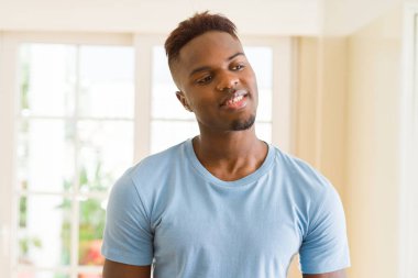 Büyük bir gülümseme ile neşeli gülümseyen yakışıklı Afrikalı genç adam 