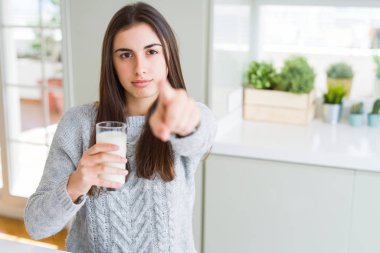 Güzel genç kadın kameraya parmakla işaret eden taze süt bir bardak içme ve size, el işareti, önden olumlu ve kendinden emin jest