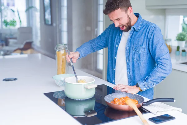 Hombre guapo cocinando pasta en casa — Foto de Stock