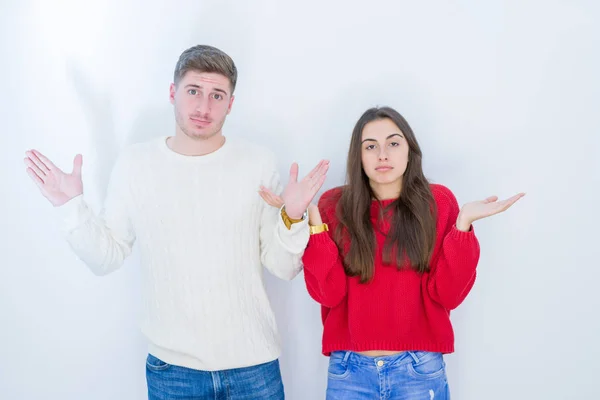 Schönes Junges Paar Vor Weißem Isoliertem Hintergrund Ahnungslos Und Verwirrt — Stockfoto