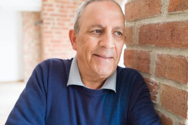 Yakışıklı orta yaş kıdemli neşeli, mutlu gülümseyen adam ve yerine koymak