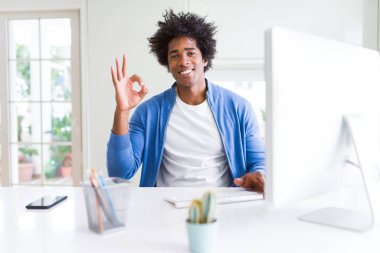 Afrika kökenli Amerikalı adam parmak, mükemmel sembolü ile ok işareti yapıyor bilgisayarla çalışma