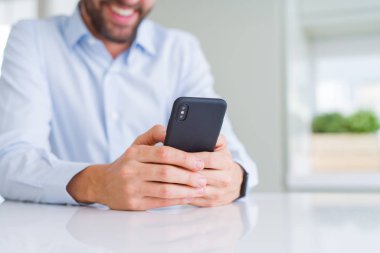 Smartphone kullanarak ve gülümseyen adam elinde yakın çekim