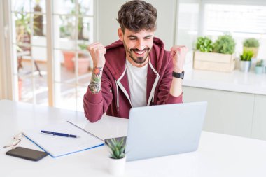 Genç öğrenci bilgisayar dizüstü bilgisayar ve dizüstü bilgisayar kullanarak gurur çığlık ve zafer ve başarı çok heyecanlı kutluyor, duygu tezahürat