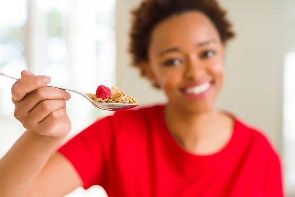 Young beautiful african american woman with afro hair eating hea — Stock Photo, Image