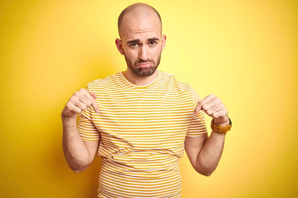 노란색 캐주얼 스트라이프 티셔츠를 수염을 대머리 남자는 슬프고 아래로 가리키며 — 스톡 사진