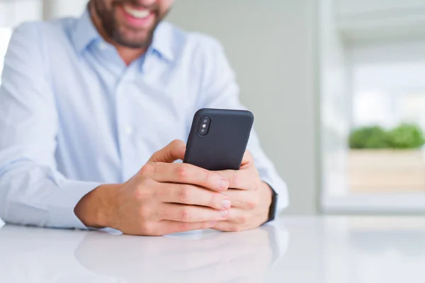 Primer plano de las manos del hombre usando el teléfono inteligente y sonriendo —  Fotos de Stock