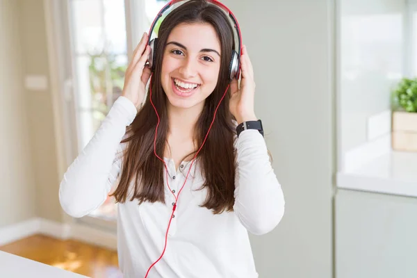 Vacker ung kvinna bär hörlurar lyssnar på musik, enj — Stockfoto