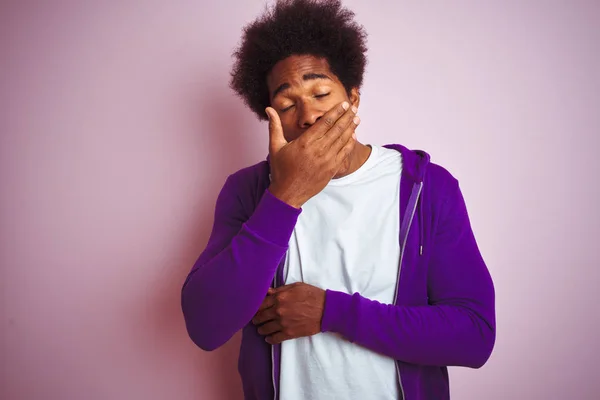 年轻的非洲裔美国男子穿着紫色运动衫站在孤立的粉红色背景无聊打哈欠疲惫的捂住嘴用手 不安和嗜睡 — 图库照片