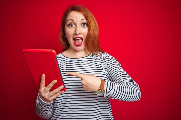 Mulher Ruiva Bonita Nova Usando Tablet Sobre Fundo Isolado Vermelho — Fotografia de Stock