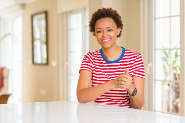Genç güzel Afrikalı-Amerikalı kadın evde birlikte elleri ve çapraz rahat ve neşeli gülümseyen parmak. Başarı ve iyimser