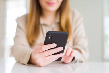 Akıllı telefon ve gülümseyen emin kullanarak kadın yakın