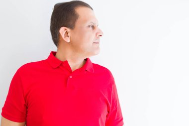 Beyaz duvar tarafına, seyir üzerinde kırmızı t-shirt giyen orta yaş adam sakin ol kendine güvenen gülümseme ile doğal yüz pozuyla profili.