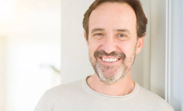 Bonito homem de meia-idade sorrindo olhando para a câmera em casa — Fotografia de Stock