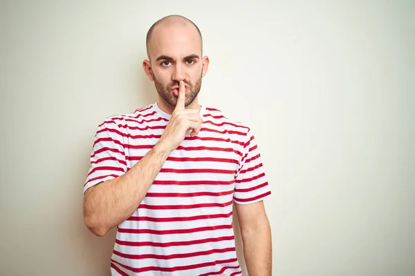캐주얼 스트라이프 티셔츠를 수염을 대머리 남자는 입술에 손가락으로 조용히 하도록 — 스톡 사진