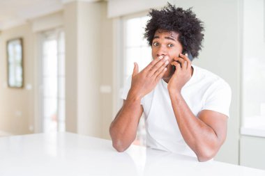 Sessizlik, gizli kavramı telefon kapağı ağız el ile konuşurken hata, korku, ifade için utanç ile şok Afrikalı-Amerikalı iş adamı korkuttu