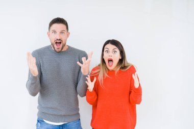 Genç güzel çift togheter üzerinde arka plan çılgın kutlama izole ve başarı için kaldırdı kollarını açarak hayrete ve heyecanlı çığlık gözleri açık. Kazanan kavramı